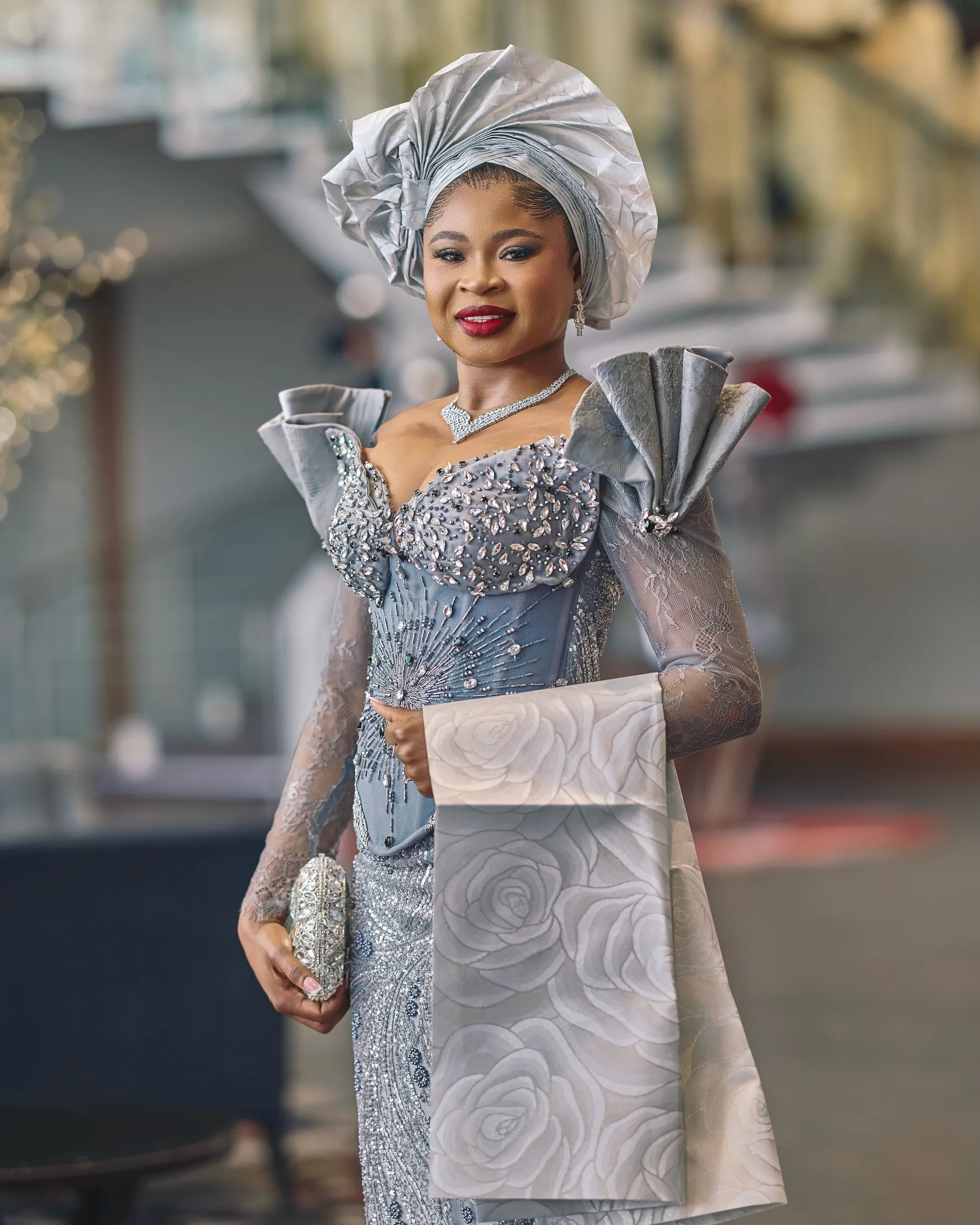 Jiofit traditional bridal look in silver-grey lace, with a beaded corset bodice, pleated shoulders and a matching gele