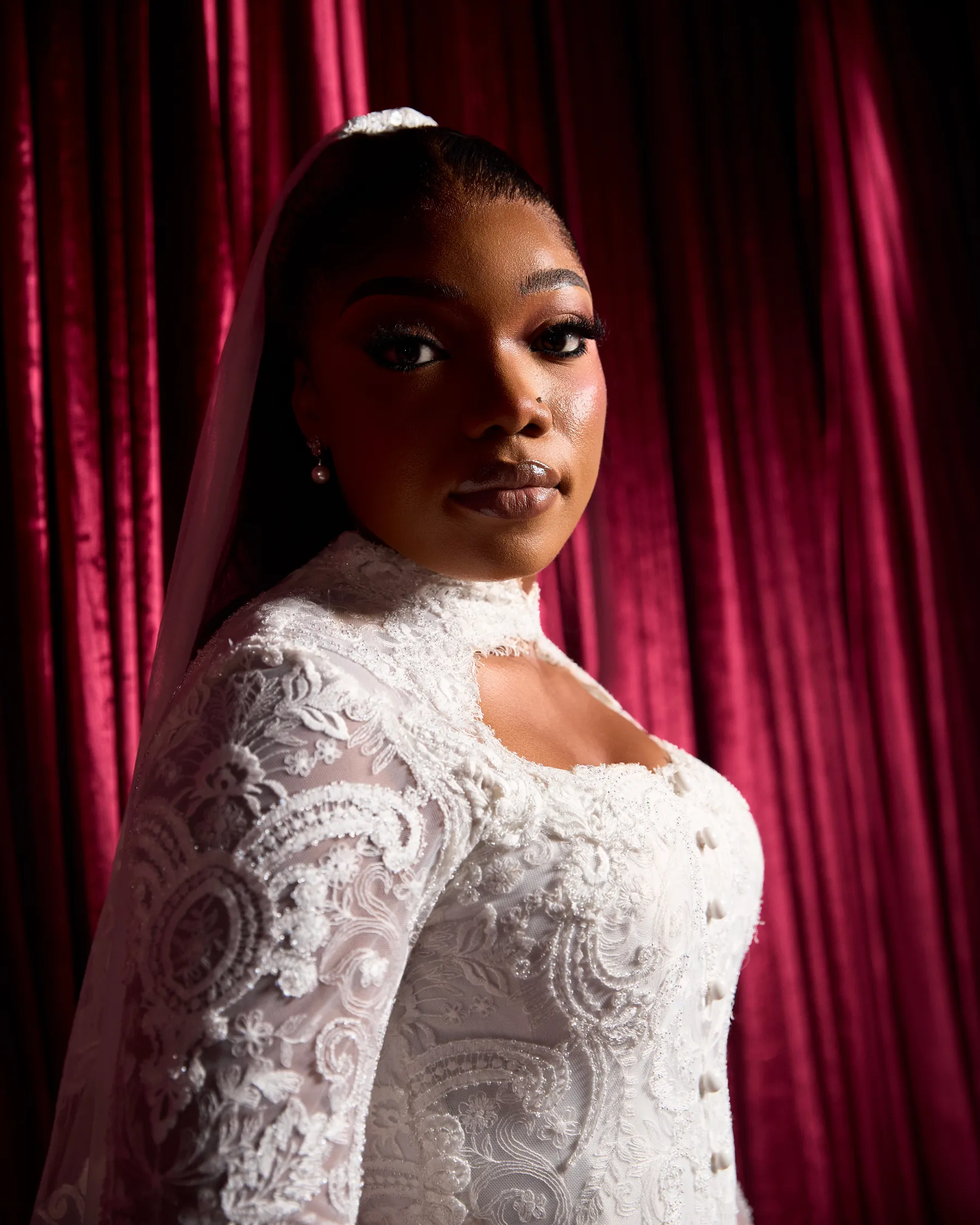 Close portrait of the Jiofit bride, showing the corded lace sleeves, keyhole collar and covered buttons of her gown