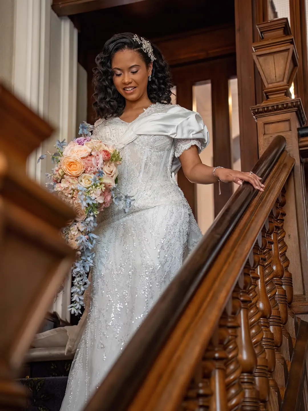 Bride descending a staircase in a Jiofit couture gown